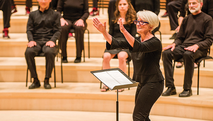 Ann Carlson, foreground, conducts an orchestra