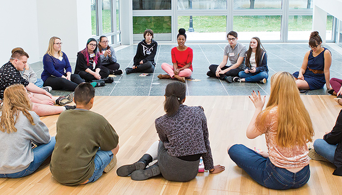 Students sit in a circle in the galleries
