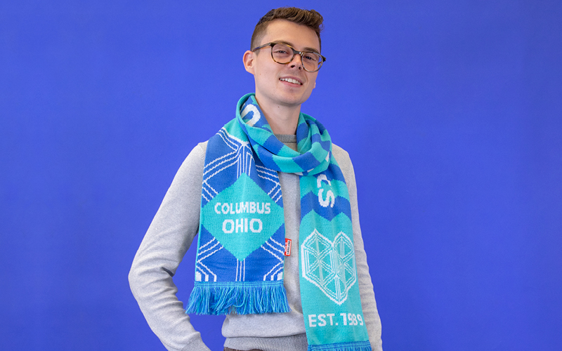 Wexner Center Design intern Michael Fletcher wearing the WEX Museum League Scarf by Maurizio Cattelan, designed exclusively for the Wexner Center Store