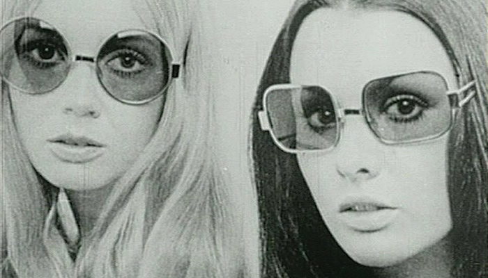 Photo image of two young white women with long straight hair, wearing sunglasses, from Julia Reichert & Jim Klein's 1970 documentary film Growing Up Female