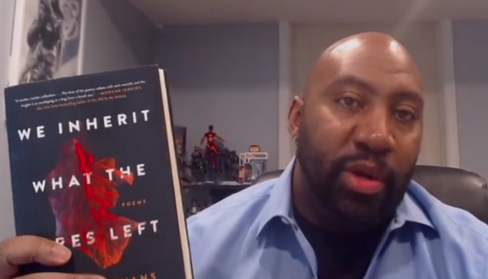 Author William Evans holding up a copy of his new book We Inherit What the Fires Left