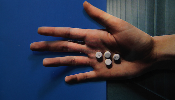 Hand holding pills from Lewis Klahr's Circumstantial Pleasures