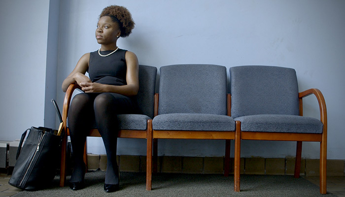 Mayoral candidate Myya Jones sits on a bench in a waiting room