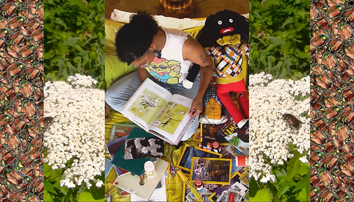 Filmmaker Bobby T. Luck reading a picture book at the center of the frame, bordered on each side by vertical strips of colorful pattern and white wildflowers, in a scene from his short film Bethel II