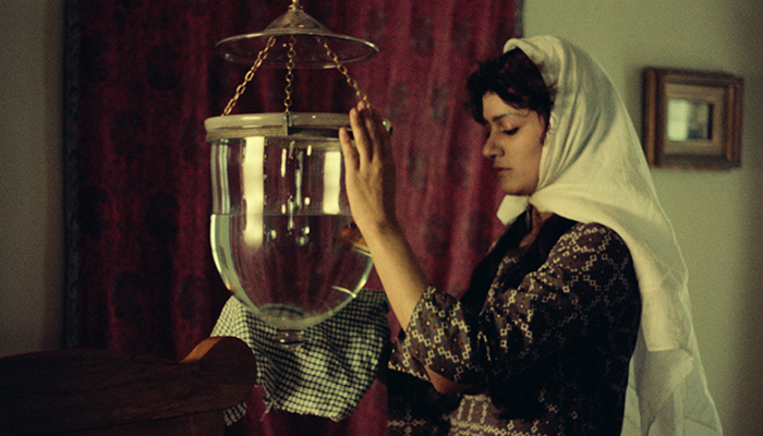 A woman wiping a glass jar full of water