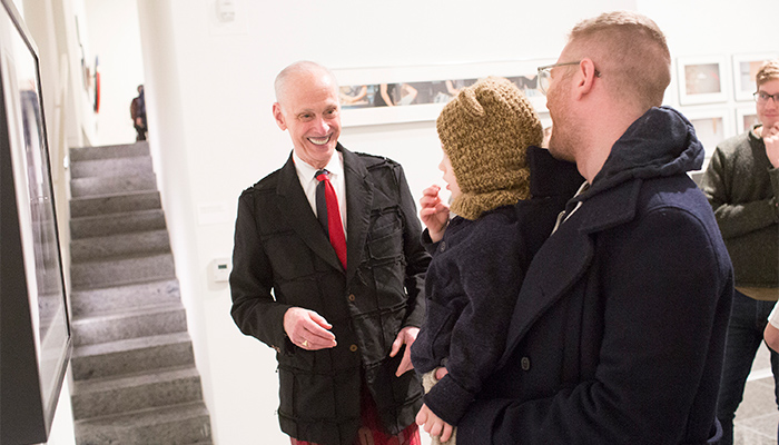 John Waters laughing with patrons in the Wex Galleries