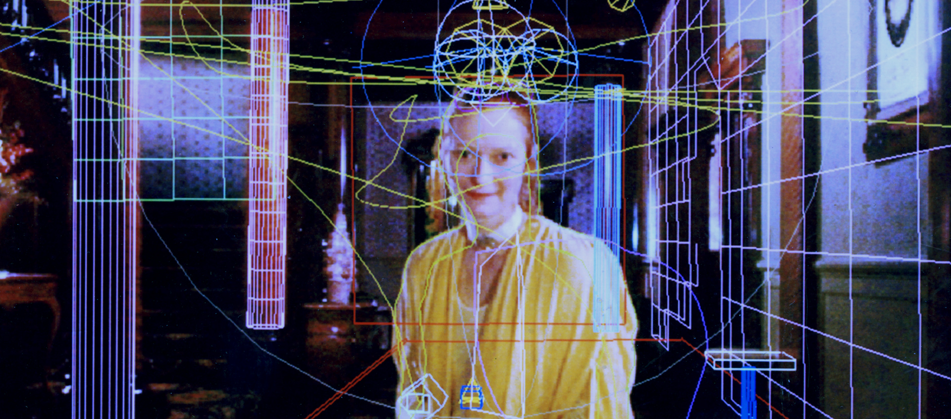 An image of Tilda Swinton wearing an all yellow outfit. She stares at the viewer and in her hands sits a digitally drawn bird. The image itself is overlaid with multi-colored lines and digital shapes